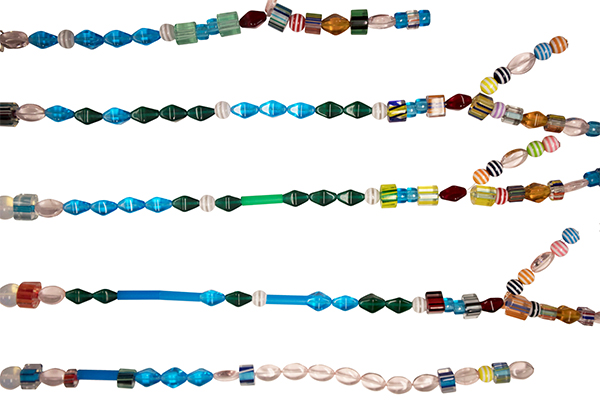 Five strands of varying styles of beads with branching strands attached to three of the five strands