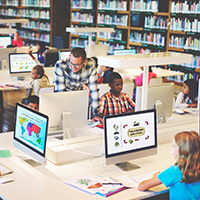 Children working on desktop computers in a library computer lab