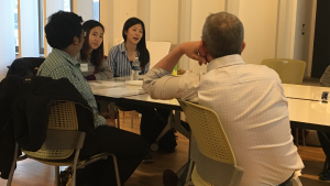 Three students sitting in discussion with Dr. Tim McKay