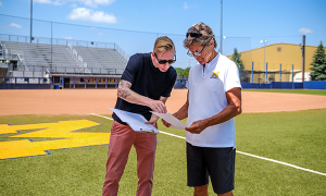 Benjamin Morse talking to Coach Hutchinson on the softball field