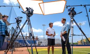 Jeff Butler filming Coach Hutchinson being interview on the softball field