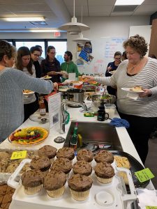 People gathered around a kitchen eating food