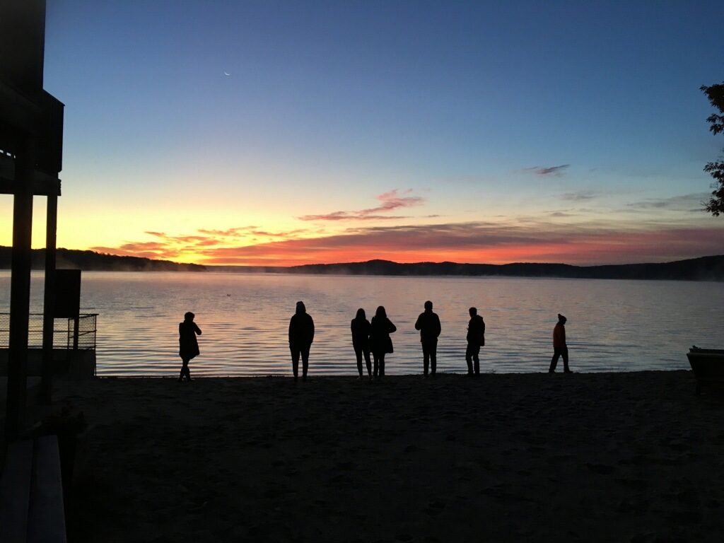 Students walking on the beach at sunset