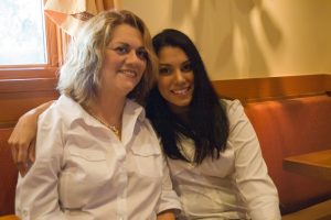 Priscilla Nuñez sitting with her arm around Yvonne Matos