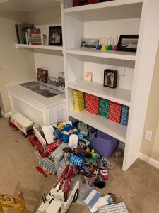 Toys on floor below bookcase