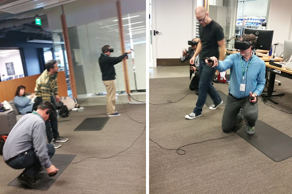 men testing out Oculus VR headsets in large room