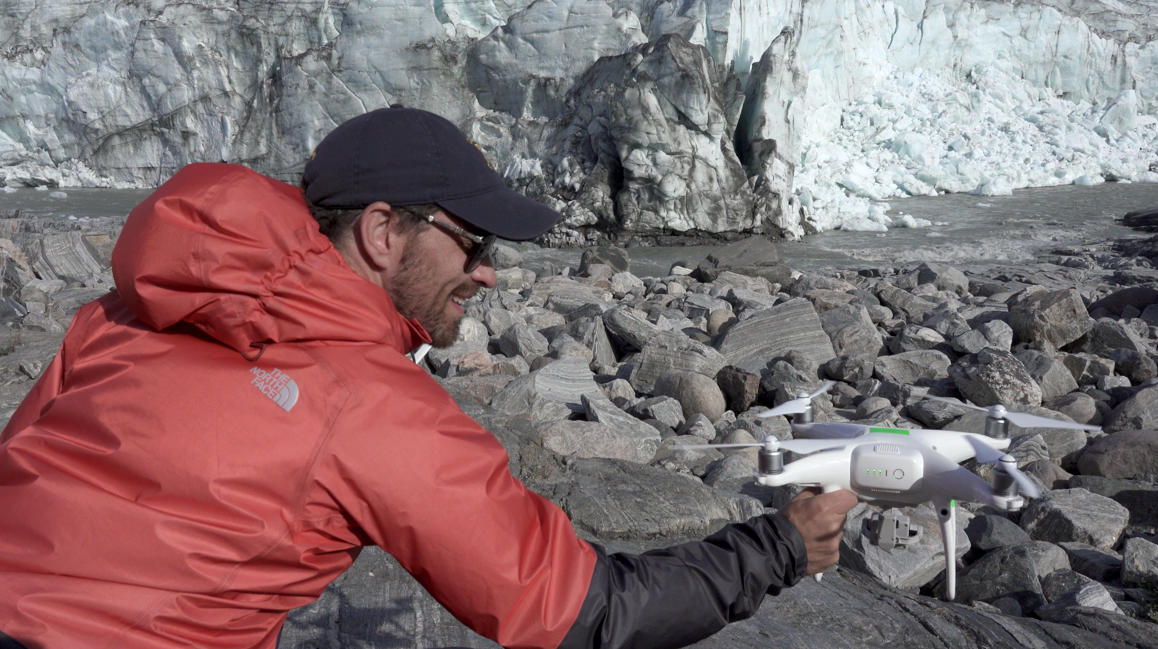 Man holding drone on rocky surface in Greenland