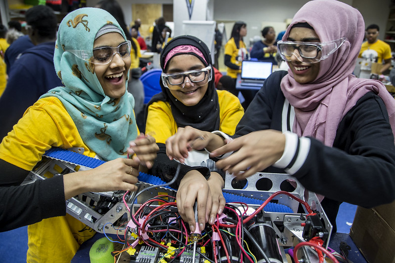 Three women working on a robotics projects