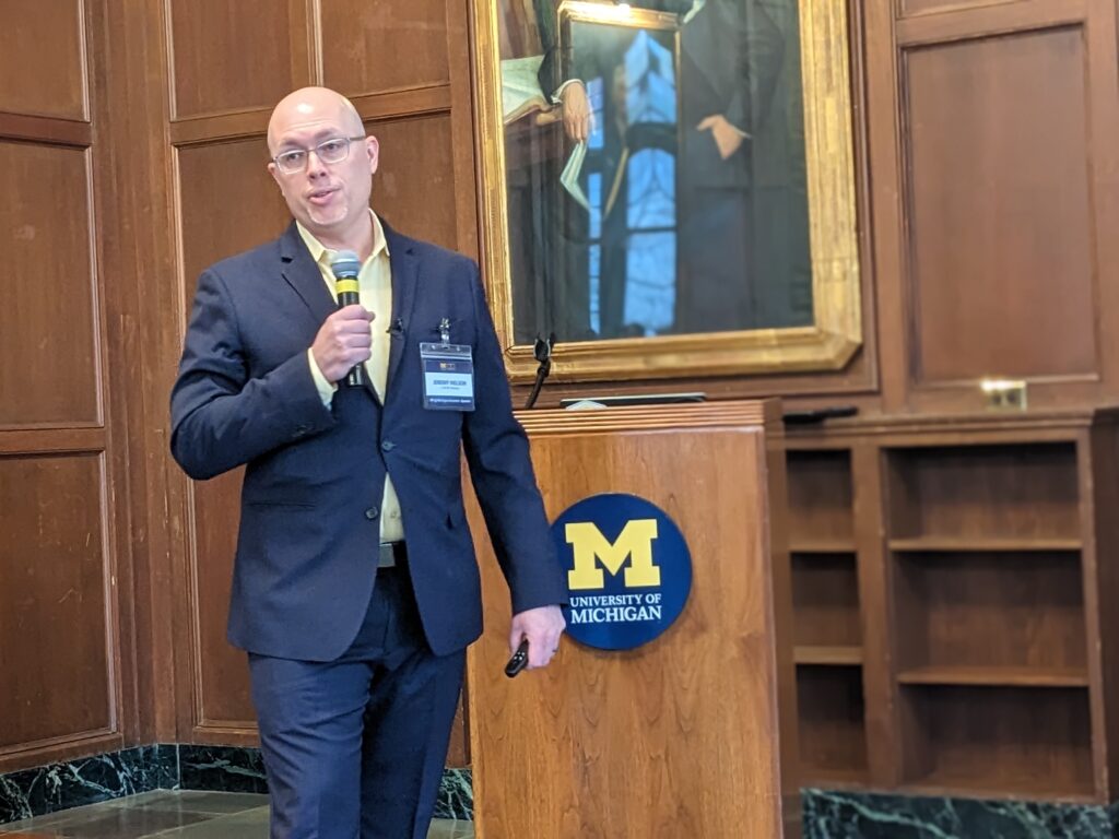 person holding a microphone in front of a lectern. 