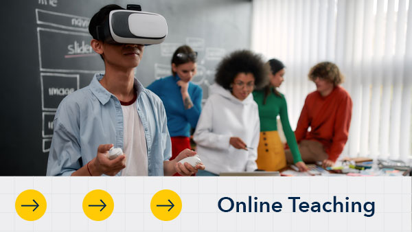 A student uses a virtual reality headset with controllers in a classroom as four other students interact in the background near a table. The text “Online Teaching” appears at the bottom beside arrow icons.